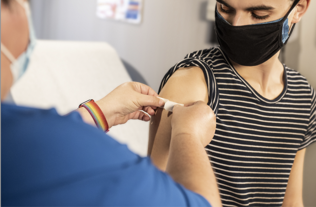 Doctor putting band-aid on patient's arm