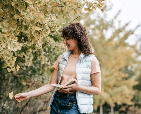 Mujer disfrutando del aire libre con síntomas de asma controlados durante la temporada de alergias de otoño.