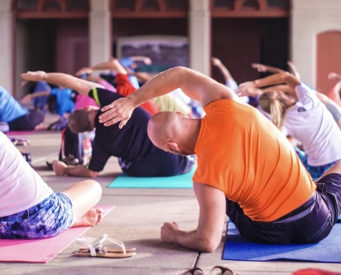 Class of people doing yoga poses on exercise mats