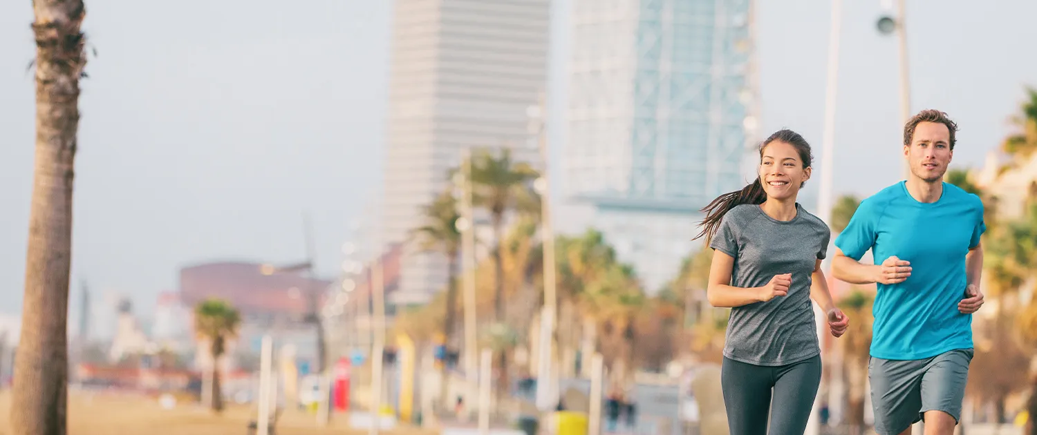 Woman and man jogging by the beach