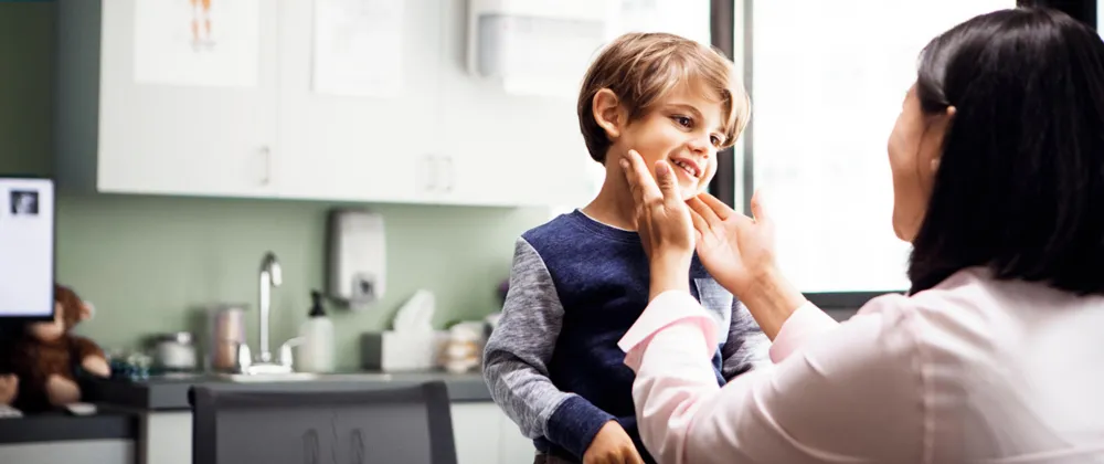 Doctor examining a young boy's face