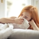 Girl sneezing into tissue