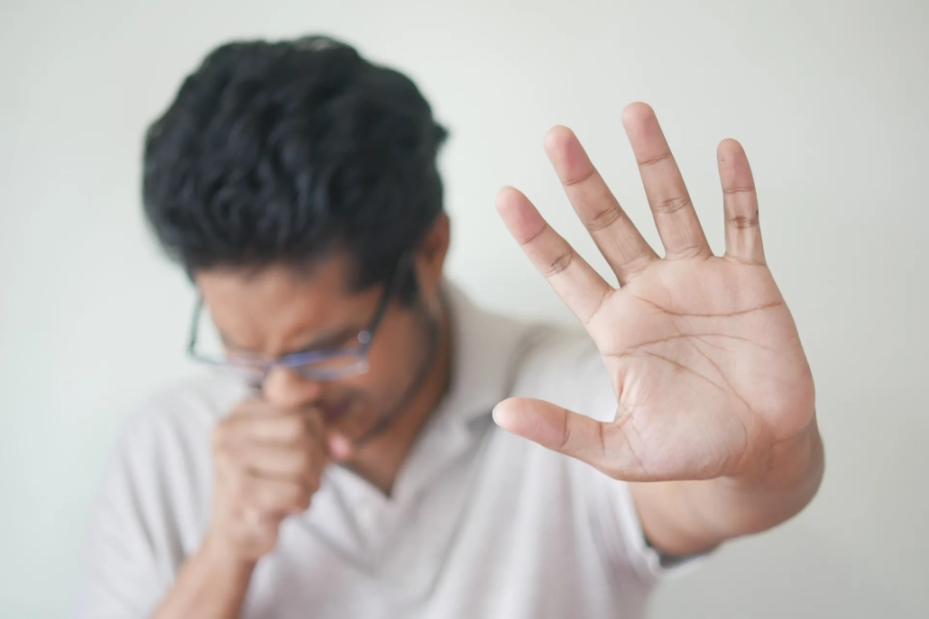 Man sneezing into tissue