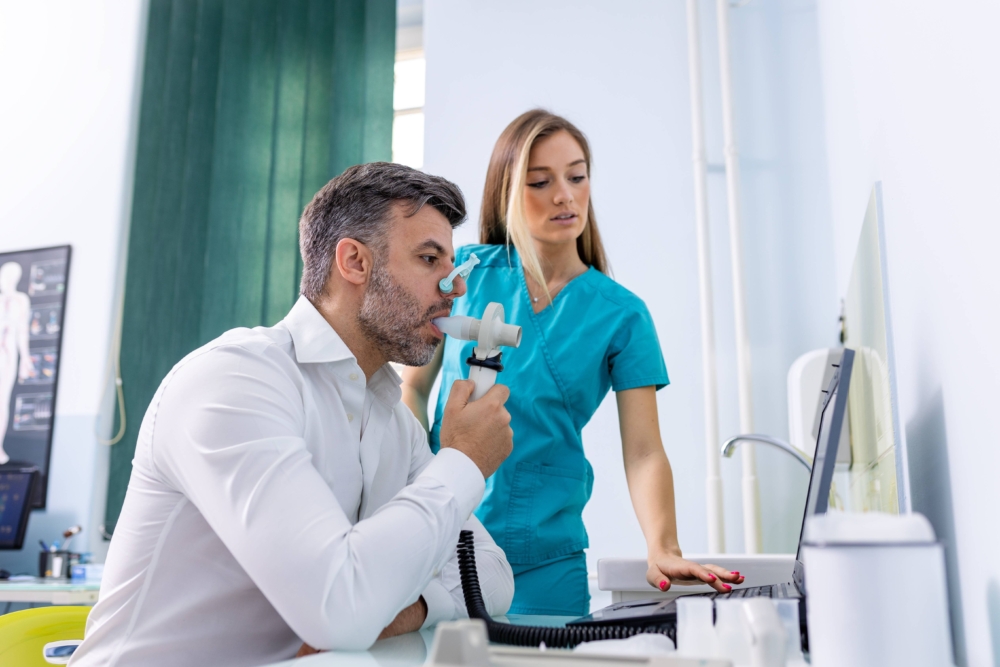 Adult man completing a spirometry test to evaluate lung function for asthma diagnosis 